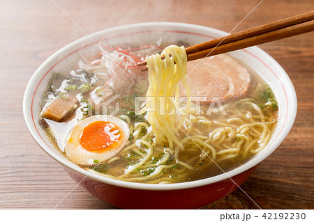 熱々の醤油ラーメンを箸で摘む 42192230