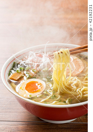 熱々の醤油ラーメンを箸で摘む 42192231