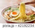 熱々の醤油ラーメンを箸で摘む 42192234