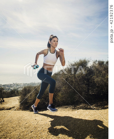 Woman jogging on mountain with water bottle Woman jogging on mountain with water bottle 42192376