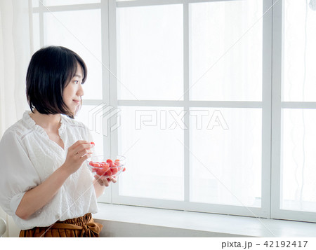 Woman having breakfast on window Woman having breakfast on window 42192417