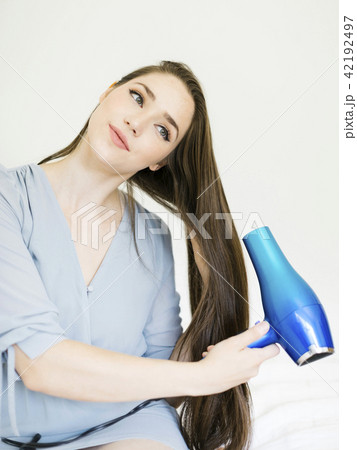 Woman using hair dryer Woman using hair dryer 42192497