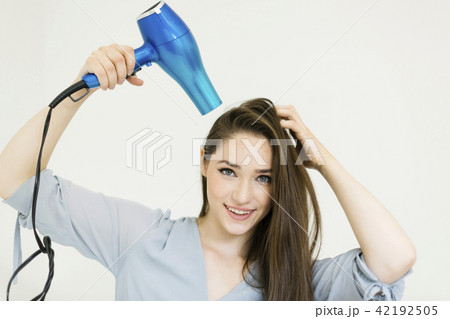 Woman using hair dryer Woman using hair dryer 42192505