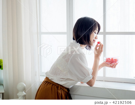 Woman having breakfast on window Woman having breakfast on window 42192506