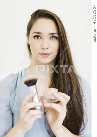 Woman holding powder and make up brush Woman holding powder and make up brush 42192507