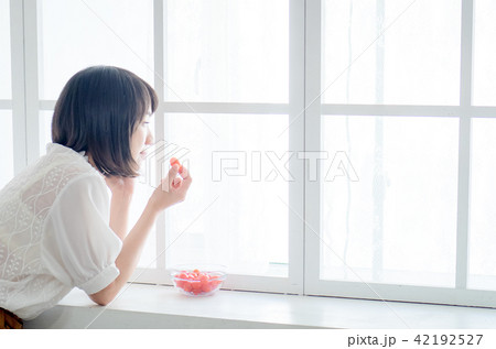 Woman having breakfast on window 42192527