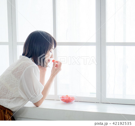 Woman having breakfast on window Woman having breakfast on window 42192535