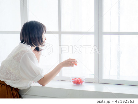 Woman having breakfast on window Woman having breakfast on window 42192562