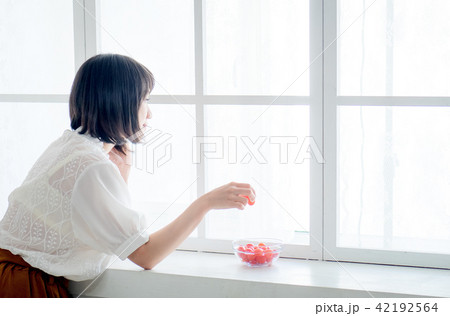 Woman having breakfast on window Woman having breakfast on window 42192564