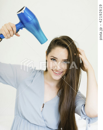 Woman using hair dryer Woman using hair dryer 42192619