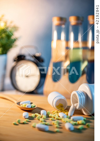 Pills spilling out of pill bottles on wooden table Pills spilling out of pill bottles on wooden table 42192841