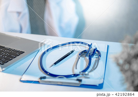 Stethoscope, clipboard and laptop on doctor desk 42192864