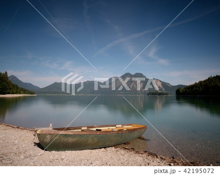 Abandoned fishing boat on bank of Alps lake.  42195072
