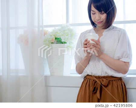 young woman standing in front of window 42195806