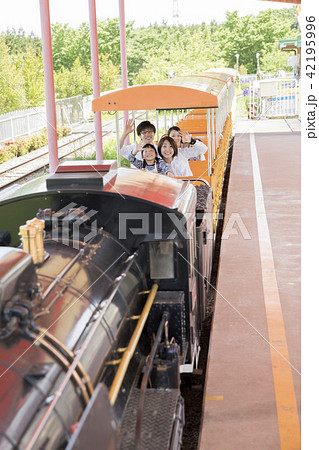 遊園地内を汽車で巡る家族 42195996