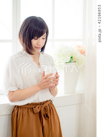 young woman standing in front of window 42196953