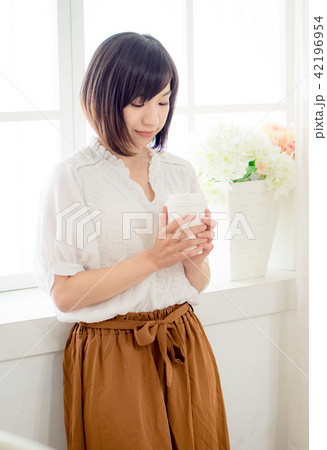 young woman standing in front of window 42196954