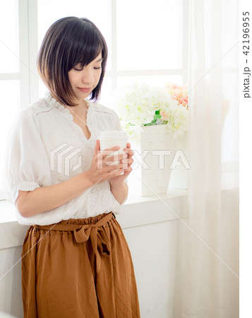 young woman standing in front of window 42196955