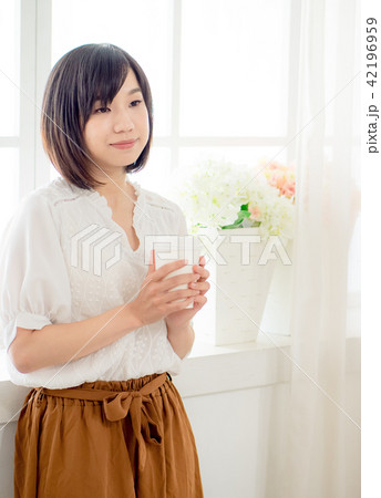 young woman standing in front of window 42196959