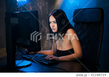 Professional Girl Gamer Plays in MMORPG or Strategy Video Game on Her Computer. She's Participating Professional Girl Gamer Plays in MMORPG or Strategy Video Game on Her Computer. She's Participating 42199724