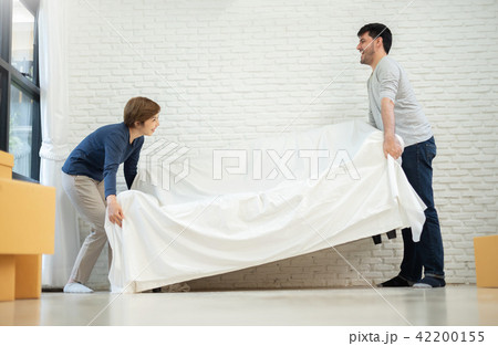 Couple lifting sofa at their new home together. Couple lifting sofa at their new home together. 42200155
