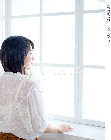 young woman standing in front of window 42200237