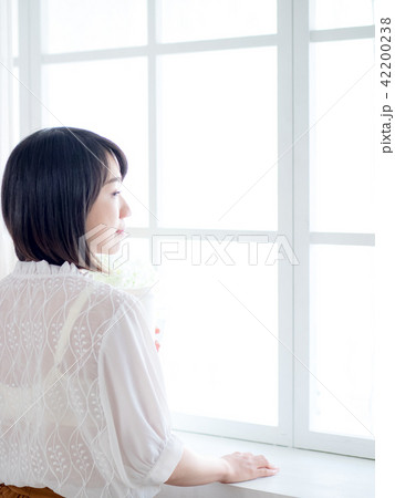 young woman standing in front of window 42200238