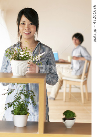 じょうろを持ち微笑む女性 42201636