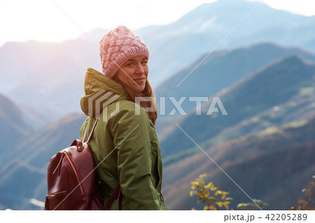Charming young woman against mountain landscape Charming young woman against mountain landscape 42205289