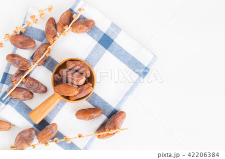 Dates fruit in wooden ladle on white background Dates fruit in wooden ladle on white background 42206384