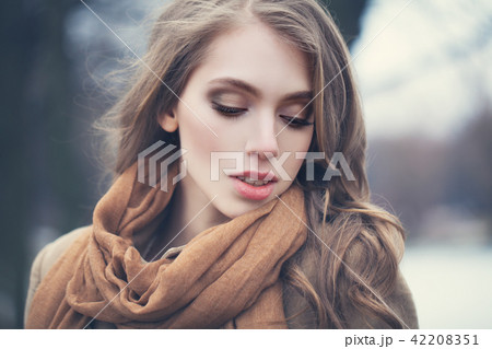 Young woman with long wave brown hair outdoors Young woman with long wave brown hair outdoors 42208351