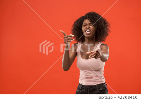 Beautiful female half-length portrait isolated on red studio backgroud. The young emotional 42208410