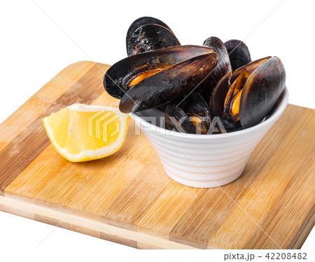 cooked mussels in a bowl with lemon 42208482