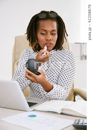Woman doing make-up at workplace Woman doing make-up at workplace 42208676
