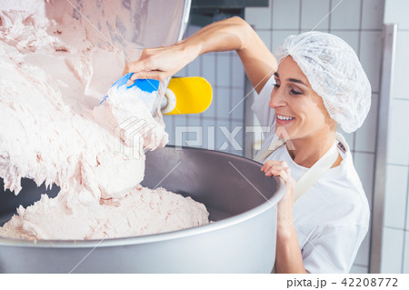 Woman working in butchery making minced meat 42208772