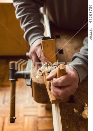 Top view of carpenter hand working with wood planer Top view of carpenter hand working with wood planer 42208786
