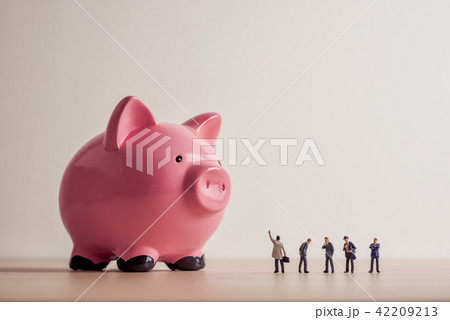 Business people looking at giant Piggy Bank 42209213