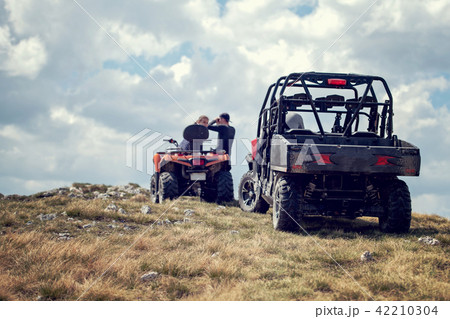 Friends driving off-road with quad bike or ATV and UTV vehicles 42210304