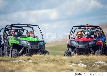 Friends driving off-road with quad bike or ATV and UTV vehicles Friends driving off-road with quad bike or ATV and UTV vehicles 42210360