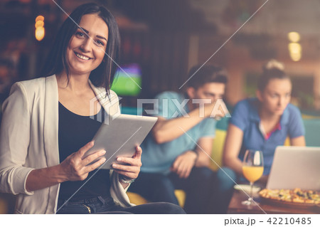 Smiling young women using digital tablet in the office 42210485