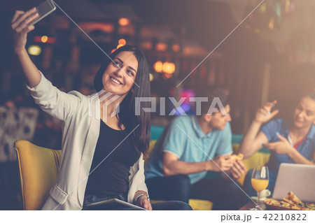 Woman taking selfie in front of her team in startup office 42210822