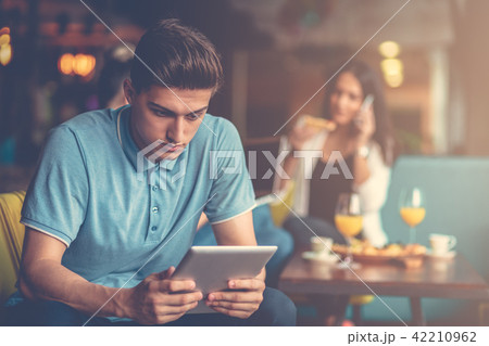 Young male using digital tablet in modern startup office Young male using digital tablet in modern startup office 42210962