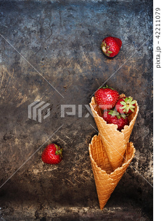 Fresh juicy strawberries in a waffle cone on a dar Fresh juicy strawberries in a waffle cone on a dar 42211079