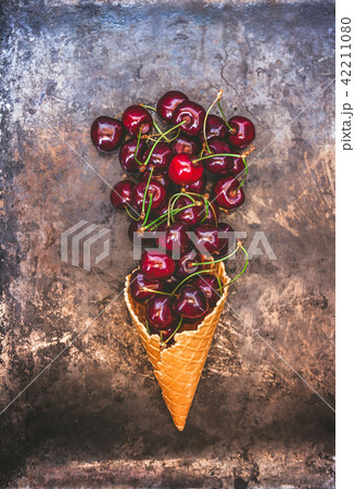 Fresh juicy cherry berries in a waffle cone on 42211080