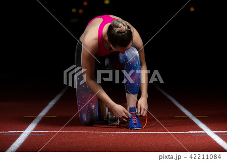 Athlete girl trying running shoes getting ready for race on track 42211084