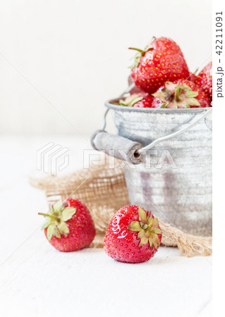 Fresh juicy strawberries in an old iron bucket Fresh juicy strawberries in an old iron bucket 42211091