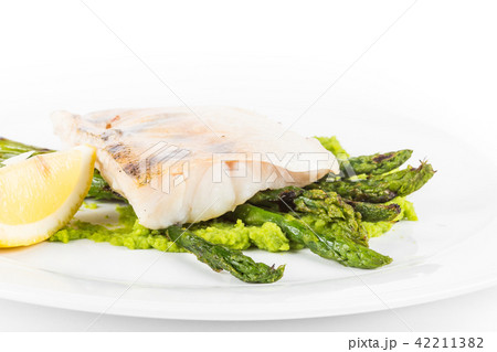 Steamed Fillet of Seabass with Green Peas Cream and Asparagus with lemon close up 42211382