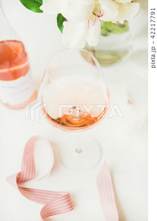 Rose wine in glass and bottle, pink ribbon, peony flowers Rose wine in glass and bottle, pink ribbon, peony flowers 42217791