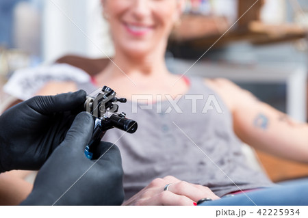 Hands of tattoo artist wearing sterile gloves 42225934