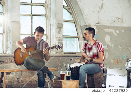 Repetition of rock music band. Electric guitar player and drummer behind the drum set. Repetition of rock music band. Electric guitar player and drummer behind the drum set. 42227929
